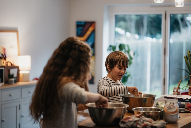 Children using a mixing bowl in a kitchen